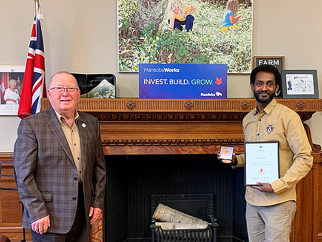 Photo of Honourable Ralph Eichler, Minister of Economic Development and Training; and Awet Biagaber, Manitoba Recipient of the 2020 COF Literacy Award