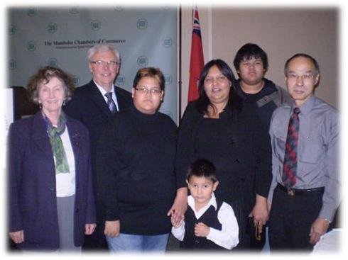 Angela avec ses fils, le premier ministre Greg Selinger, Diane McGifford, ministre de l’Enseignement postsecondaire et de ’Alphabétisation et le proposant Norm Koe