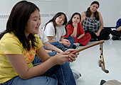 A young adolescent girl is sitting in a circle with other Middle Years students. She is learning about Aboriginal traditions.