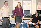 Two male teachers and one female teacher are planning for Middle Years engagement. Notes on chart paper are posted on the wall behind the teachers.