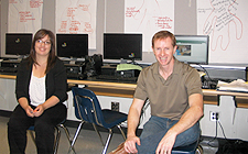 A smiling female teacher and a smiling male teacher are seated in front of completed chart papers at a Middle Years engagement professional learning session.