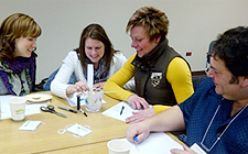 Three female teachers and one male teacher are seated at a table at a Middle Years mathematics and science professional learning session.