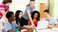 Students and their teacher in front of a computer